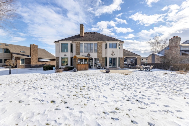 view of snow covered rear of property