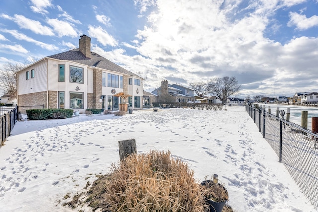 view of snow covered back of property