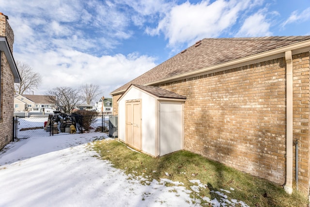 view of snow covered exterior featuring a shed