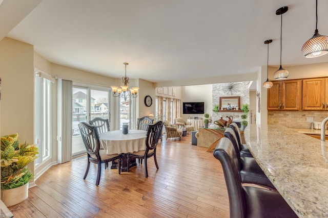 dining space with an inviting chandelier and light hardwood / wood-style floors