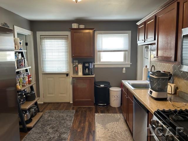 kitchen featuring dark hardwood / wood-style flooring, sink, tasteful backsplash, and stainless steel appliances