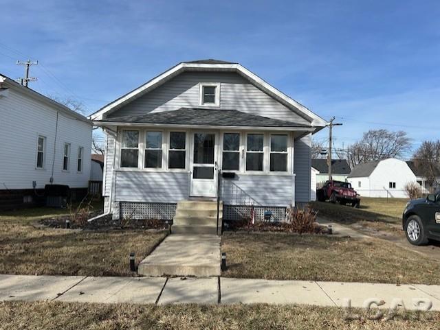 bungalow-style house with a front lawn