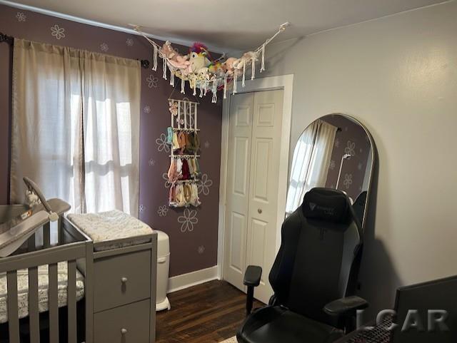 bedroom with dark hardwood / wood-style floors and a closet