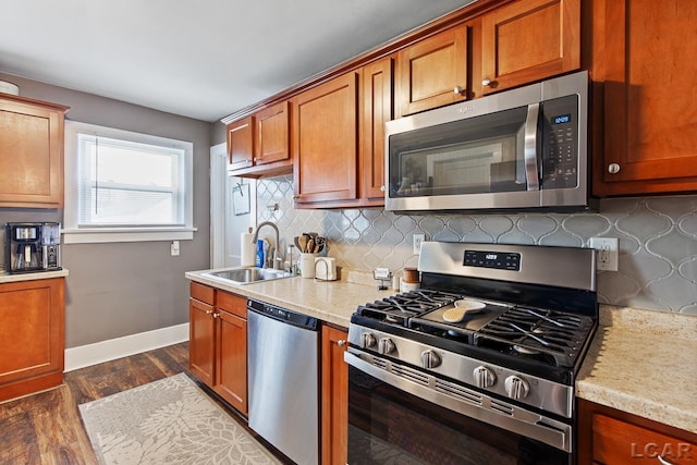 kitchen with sink, backsplash, stainless steel appliances, dark hardwood / wood-style floors, and light stone counters