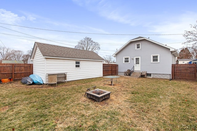 back of house featuring a yard and an outdoor fire pit