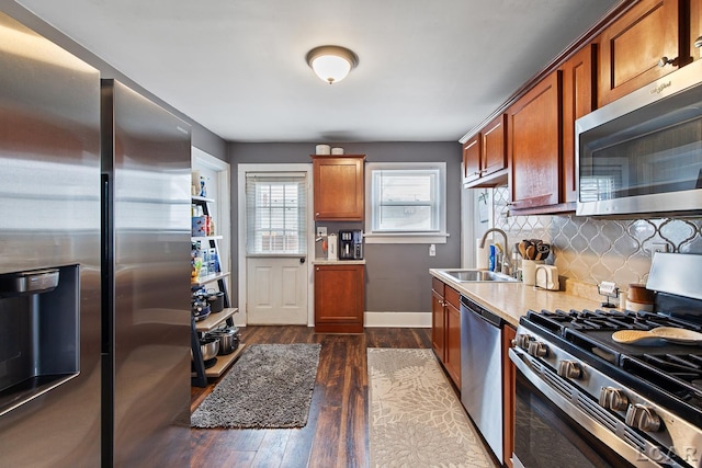 kitchen featuring appliances with stainless steel finishes, sink, dark wood-type flooring, and decorative backsplash