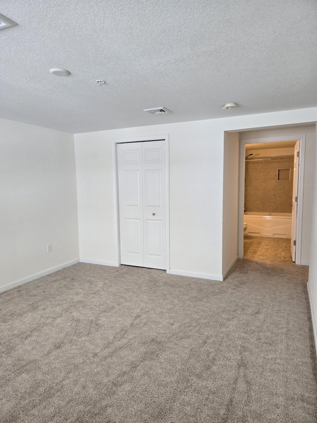 unfurnished bedroom with a closet, carpet, and a textured ceiling