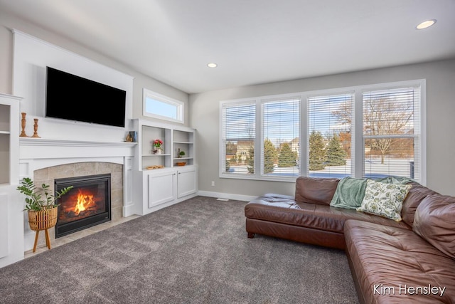 living room with a tiled fireplace and carpet