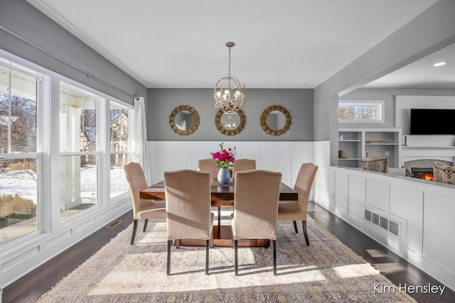 dining area with a notable chandelier and dark hardwood / wood-style flooring