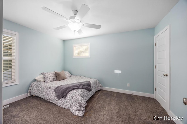 bedroom with ceiling fan and dark colored carpet