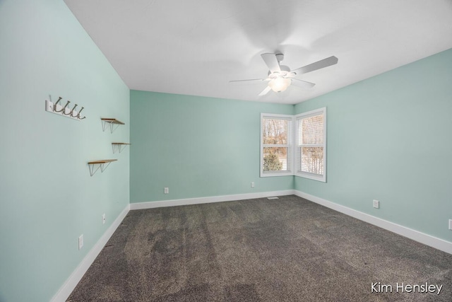 spare room featuring ceiling fan and dark carpet