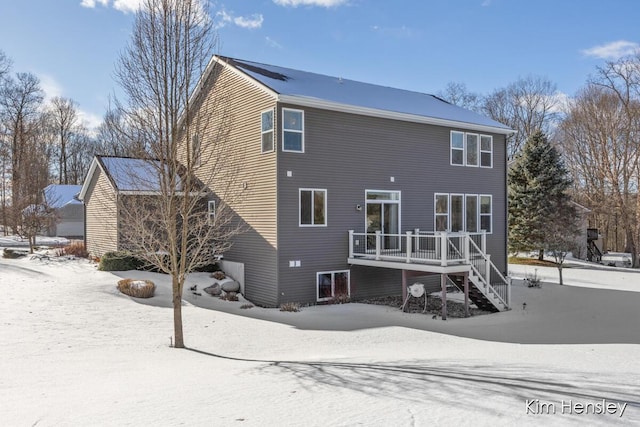 snow covered rear of property featuring a wooden deck