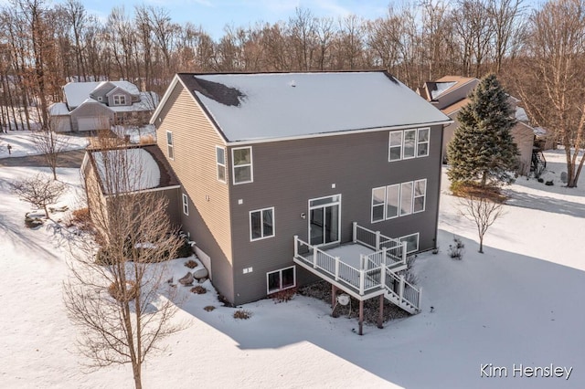 snow covered property featuring a wooden deck