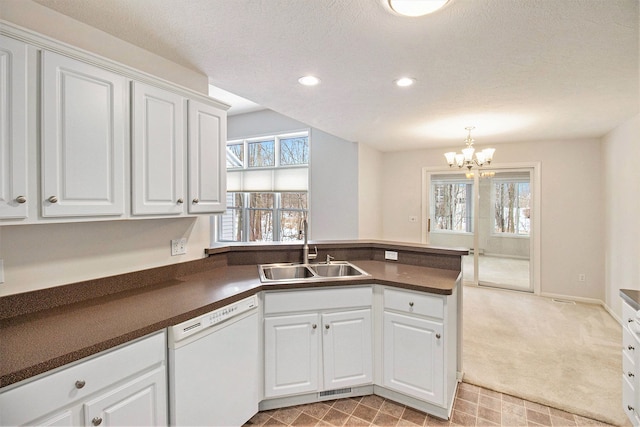 kitchen featuring white cabinetry, dishwasher, sink, and kitchen peninsula