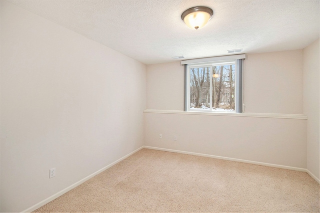 carpeted empty room with a textured ceiling