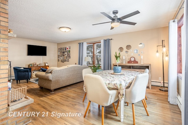 dining room featuring a baseboard radiator, hardwood / wood-style floors, ceiling fan, and a textured ceiling