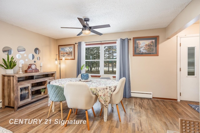 dining area featuring hardwood / wood-style flooring, ceiling fan, baseboard heating, and a textured ceiling