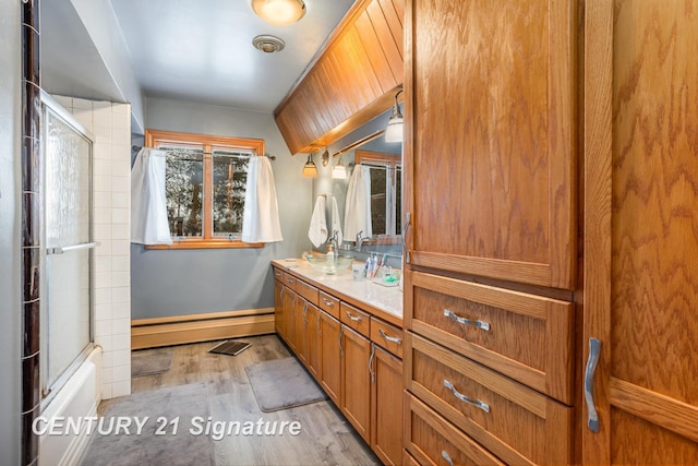 bathroom with hardwood / wood-style flooring, a baseboard radiator, combined bath / shower with glass door, and vanity