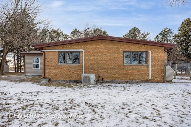 snow covered property with ac unit