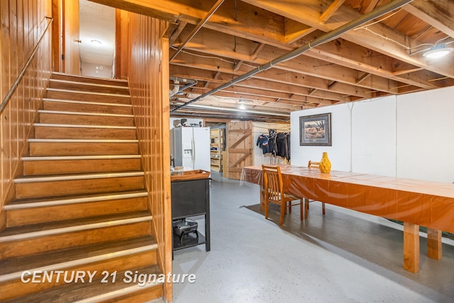 basement featuring white fridge with ice dispenser