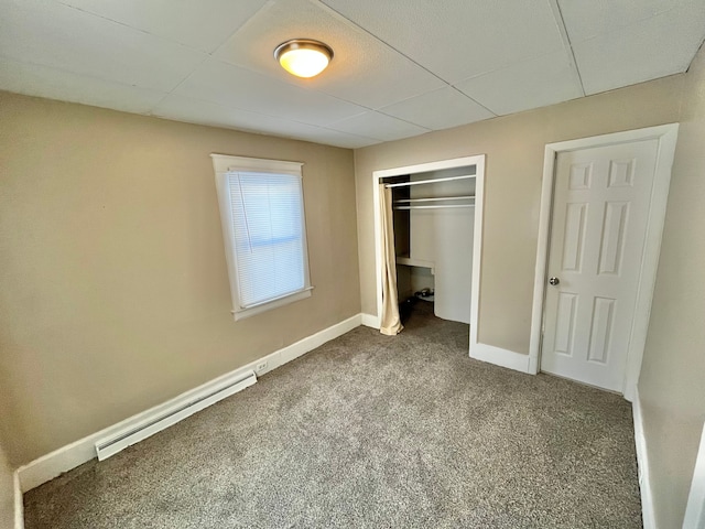 unfurnished bedroom featuring carpet, baseboard heating, and a closet