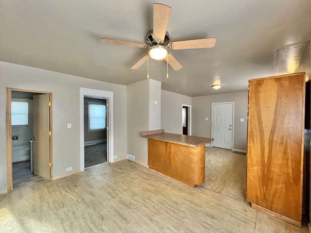 kitchen featuring light hardwood / wood-style flooring, ceiling fan, and kitchen peninsula