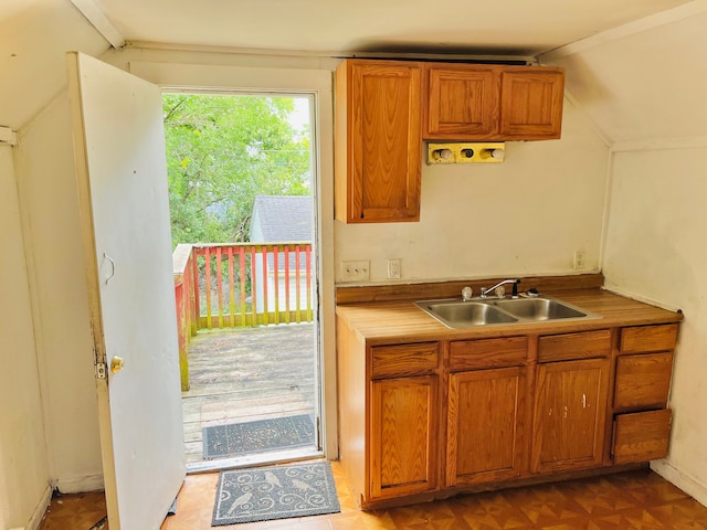 kitchen with vaulted ceiling, light parquet flooring, and sink