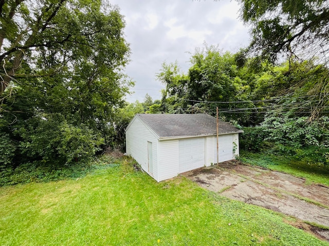 view of outdoor structure with a garage and a lawn