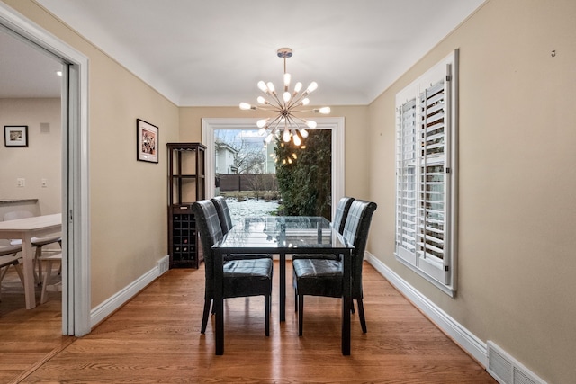 dining room with hardwood / wood-style floors and a notable chandelier