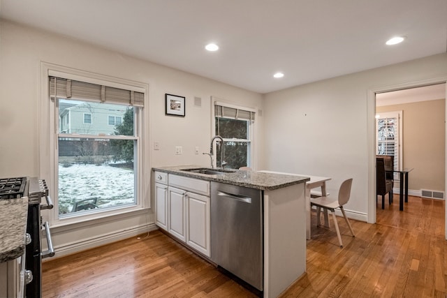 kitchen featuring white cabinetry, stainless steel appliances, light stone countertops, and sink