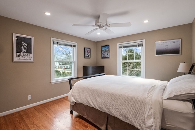 bedroom featuring multiple windows, ceiling fan, and light wood-type flooring