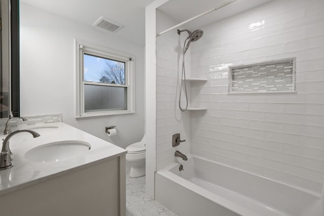 full bathroom with vanity, toilet, and tiled shower / bath