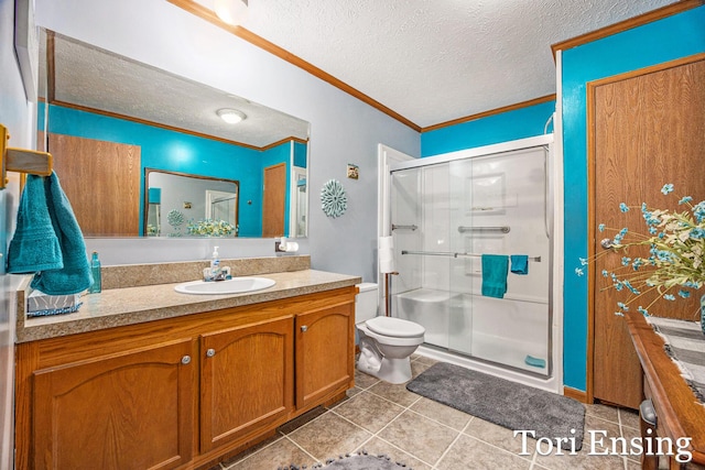 bathroom featuring a shower with door, crown molding, vanity, and a textured ceiling
