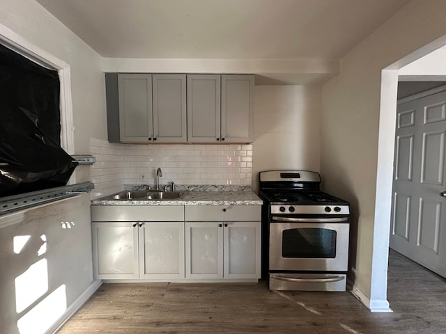 kitchen with sink, hardwood / wood-style flooring, stainless steel gas range, and gray cabinets