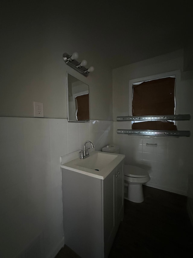 bathroom with vanity, tile walls, and toilet