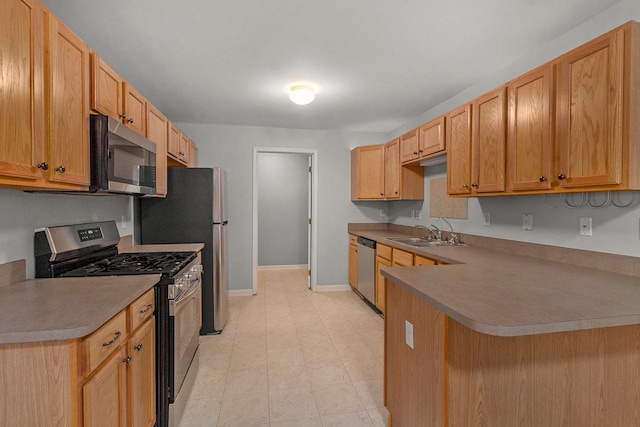 kitchen with light brown cabinetry, sink, stainless steel appliances, and kitchen peninsula