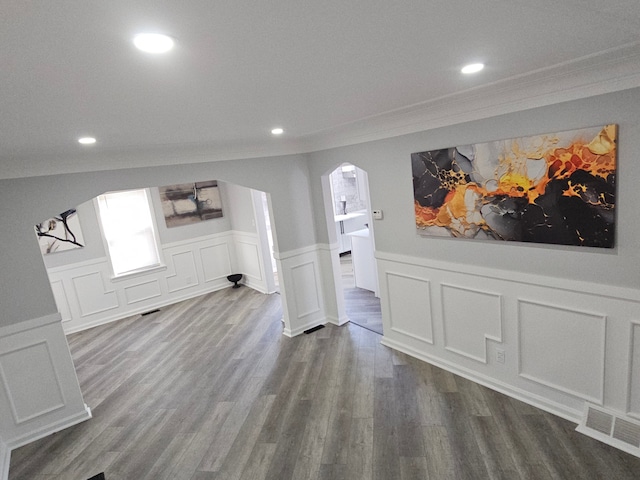 unfurnished living room featuring crown molding and hardwood / wood-style floors