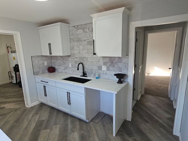 kitchen with tasteful backsplash, sink, dark hardwood / wood-style flooring, and white cabinets