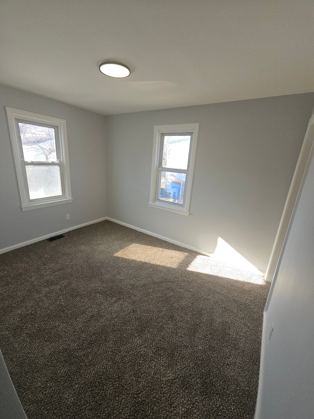 carpeted spare room featuring plenty of natural light