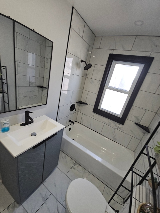 full bathroom with tiled shower / bath, vanity, and toilet