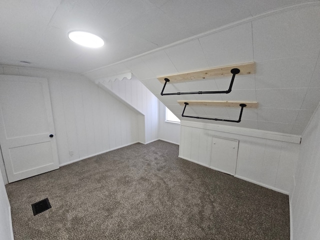 additional living space featuring dark colored carpet and lofted ceiling