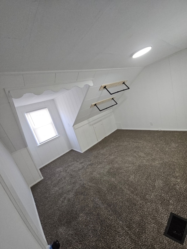 bonus room featuring lofted ceiling and dark colored carpet