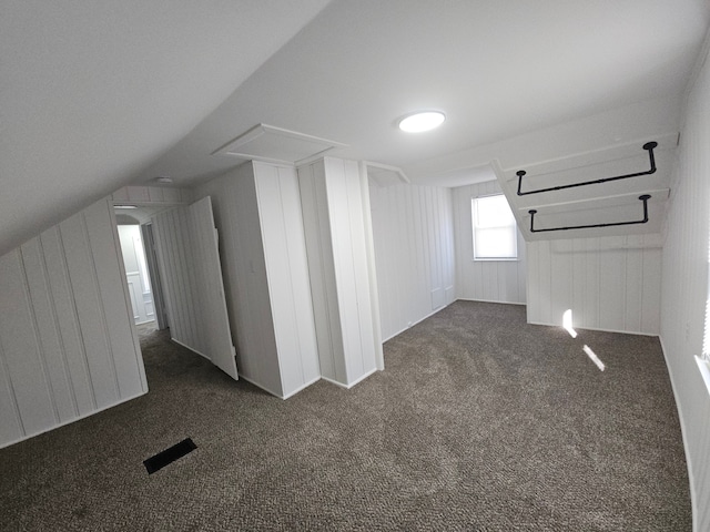 bonus room featuring lofted ceiling and dark colored carpet