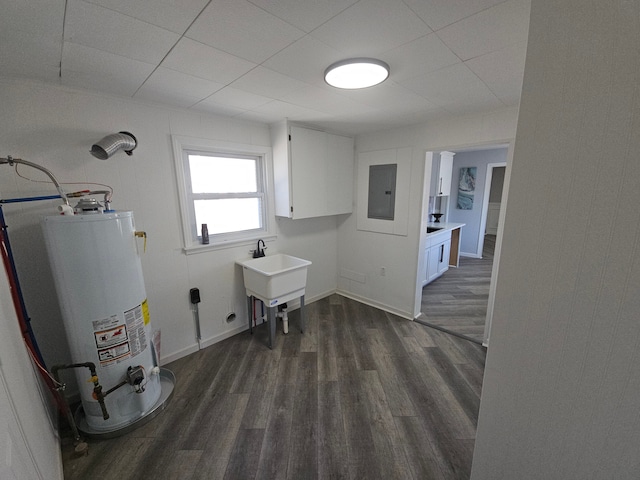 laundry area featuring cabinets, gas water heater, dark wood-type flooring, and electric panel