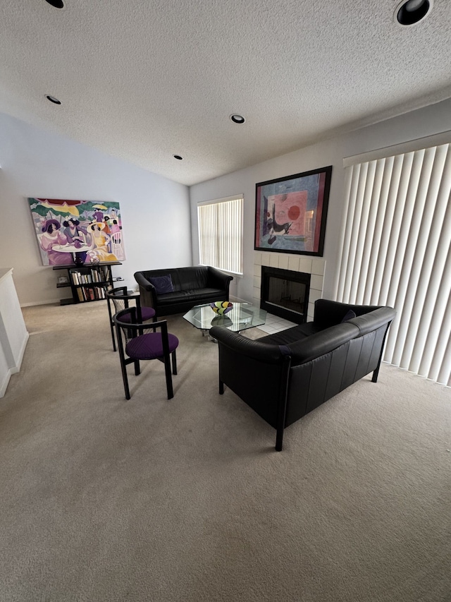 living room featuring carpet floors, a textured ceiling, and a fireplace