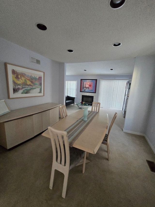 carpeted dining area featuring a textured ceiling