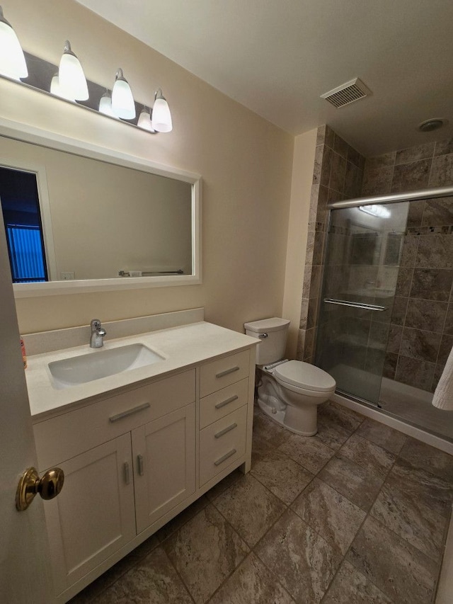 bathroom featuring a stall shower, visible vents, vanity, and toilet