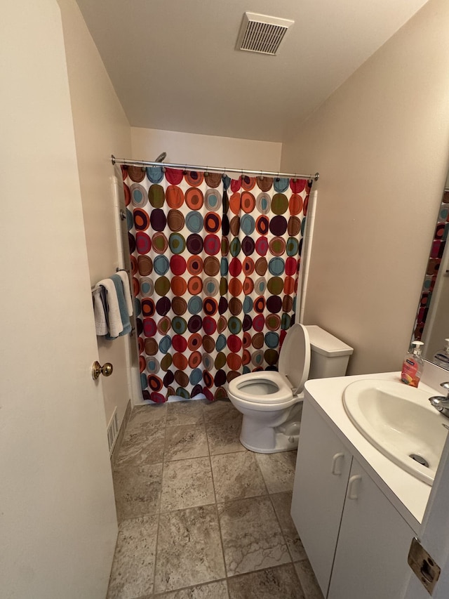 bathroom with visible vents, a shower with shower curtain, toilet, stone finish floor, and vanity