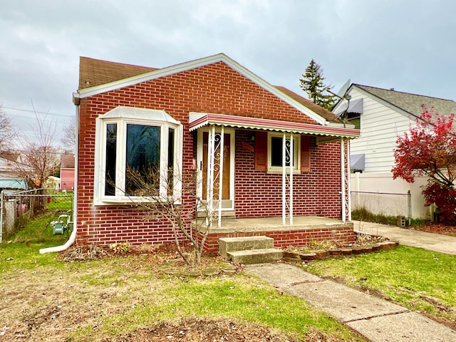 bungalow-style house with covered porch and a front lawn