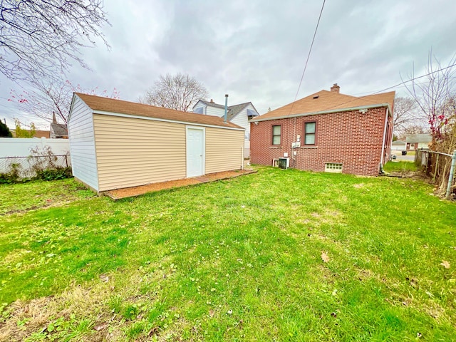 back of house featuring an outbuilding and a lawn